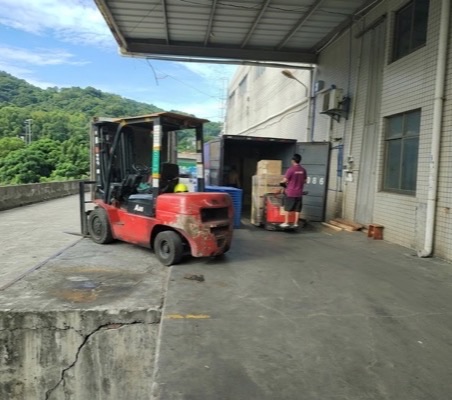 廠區戶外以堆高機與電動拖板車進行貨櫃裝卸作業